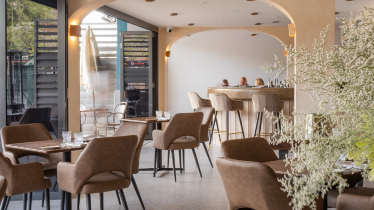 The interior of the restaurant, neutral tones, wooden leather chairs