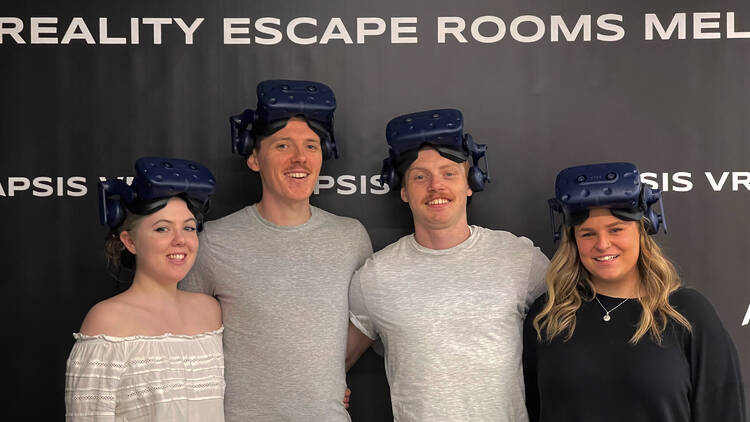 A group of four people wearing VR goggles.