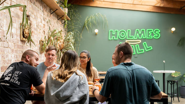 A group of friends sitting at a table inside Holmes Hall.