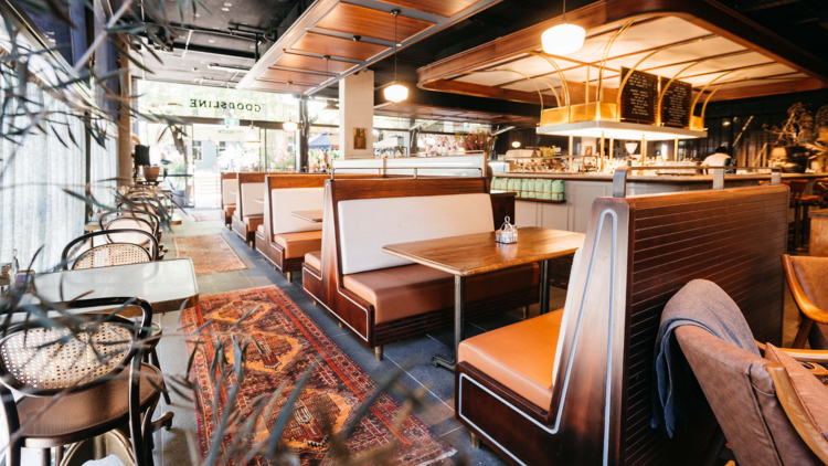 An art deco style cafe with leather booths and persian rugs