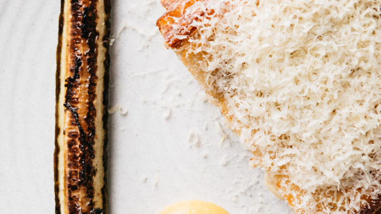 A grilled cheese toastie alongside a charred slice of zucchini and mustard