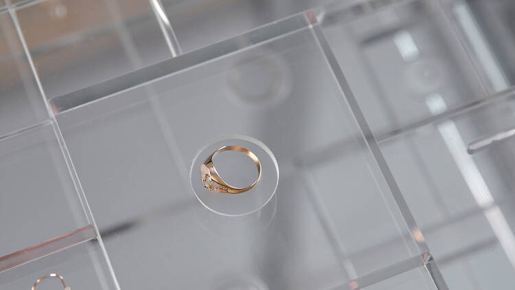 A clear glass display with rings and earrings inside.