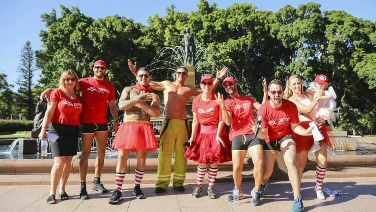 A group of people standing in front of a fountain, dressed in red and wearing undies for the Cupid's Undie Run.