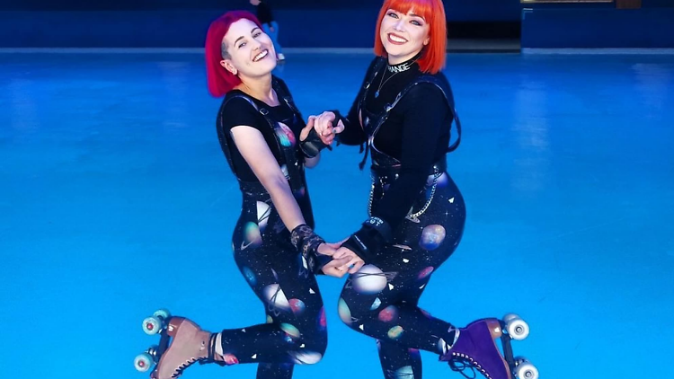 Two women wearing rollerskates at Caribbean Rollerama.