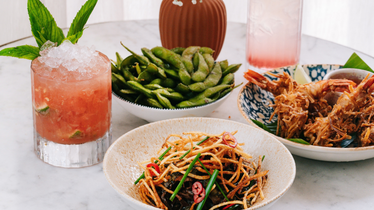 A flat lay of edemame beans, crisp king prawns, a water melon cocktail and mongolian beef
