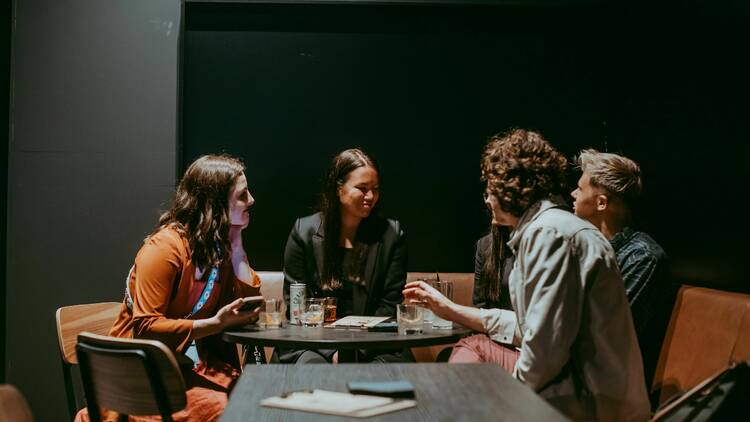 A group of friends sitting at a table inside of the Distiller.