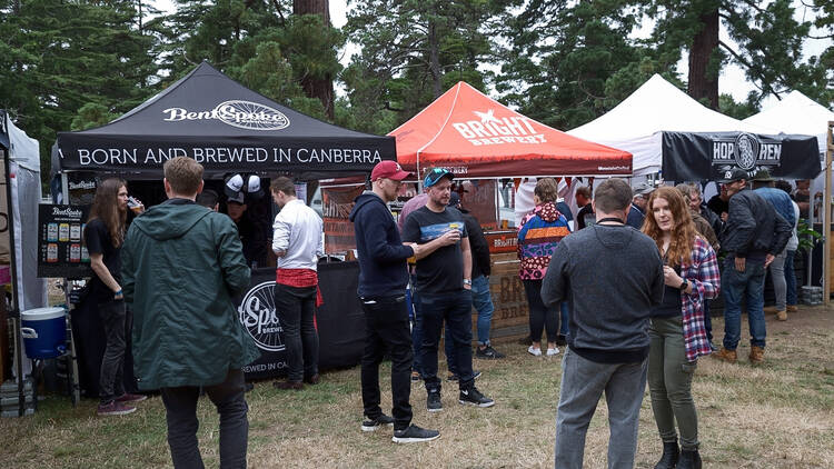 A group of people standing in front of stalls run by breweries at the Ballarat Beer Festival.