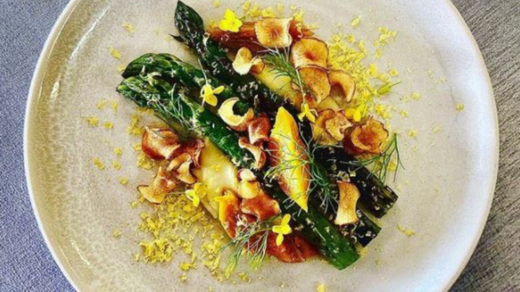 A plate of asparagus with peaches and bottarga