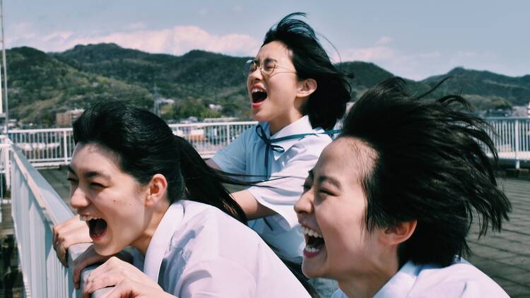 Three young Japanese women shouting joyfully