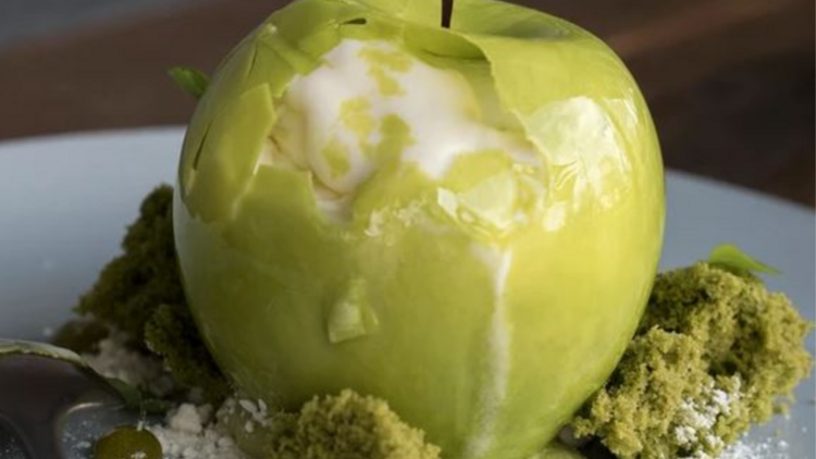 A green apple shaped toffee shell with sorbet and granita