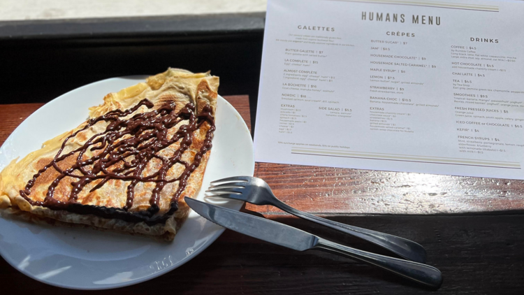 A crepe covered with chocolaet and a menu entitled 'humans menu'.