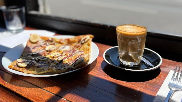 A pastry and a coffee on plates by a windowsill at Chez Misty.