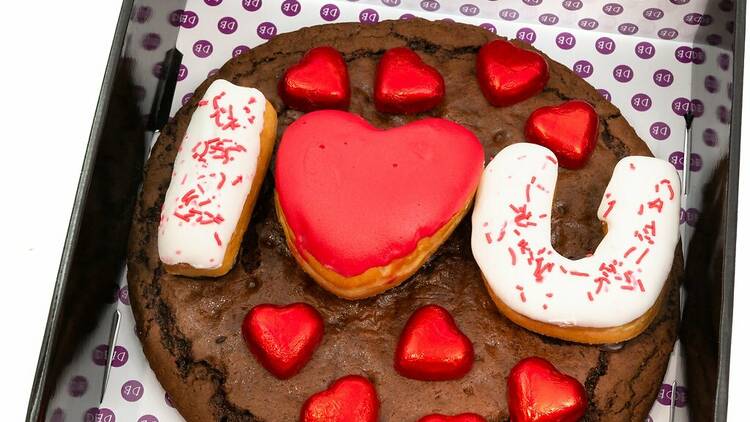 A giant chocolate cookie with 'I love you' spelled out on top in donuts