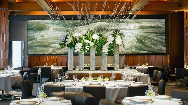 A photo of the dining room at Le Bernardin with a white floral display.