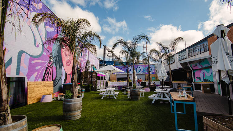 Outdoor bar Pink Lemonade, with palm trees and picnic tables