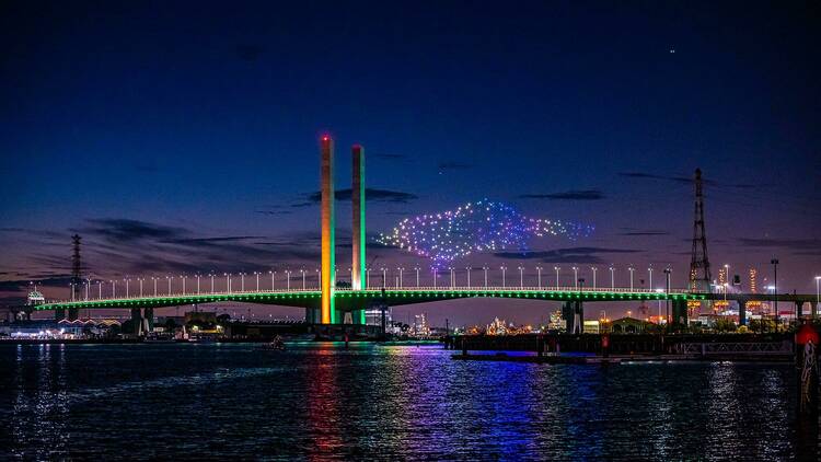 Drones in a light show over a bridge