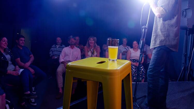 A comedian performing on stage at the Rubber Chicken