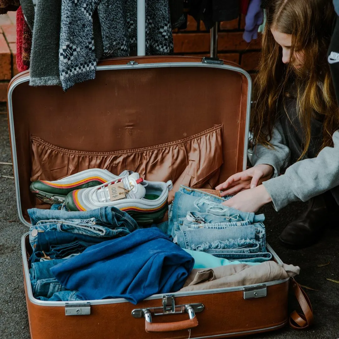 A women looks through a trunk of vintage clothes