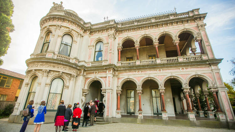 A group of people waiting in line at the doorway of Labassa Mansion.