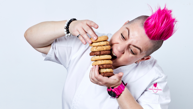 Anna Polyviou biting into a stack of cookies