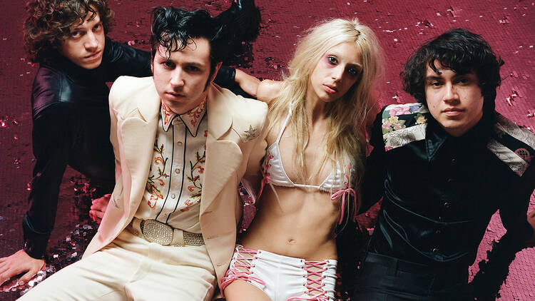 The four members of the band Starcrawler sitting on a pink floor. 