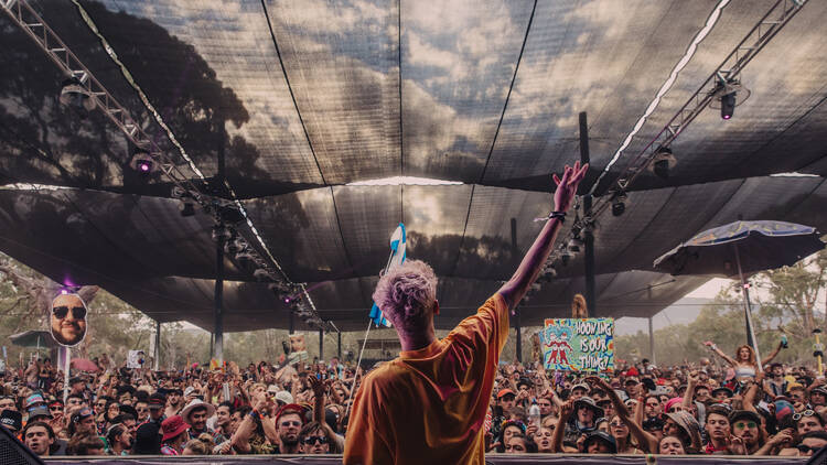View from behind the DJ booth and of a crowd. 