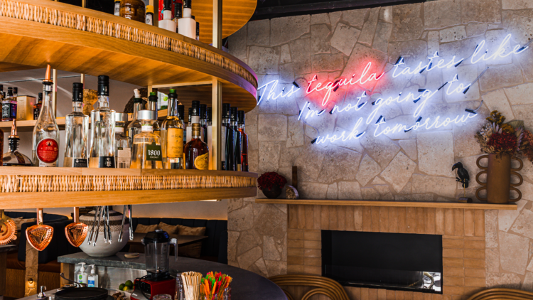 The tiki style round bar with neon signs on the wall