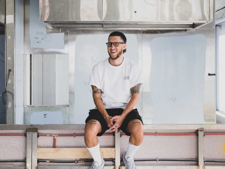 Mitch Orr sits in a construction site, smiling