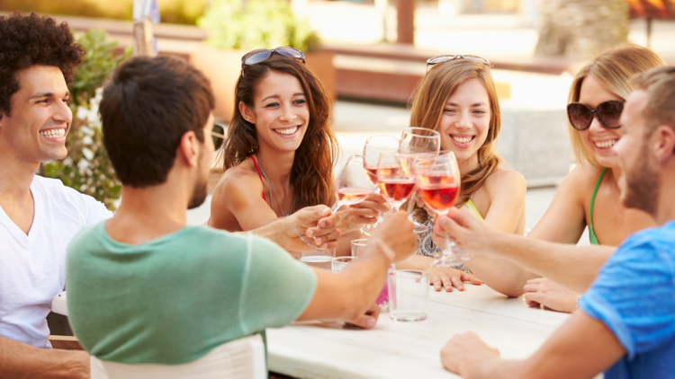 A group of happy people drinking rose, unaware what is to come