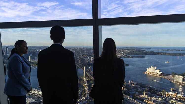 Three people take in the view from the Crown Tower Sky Deck