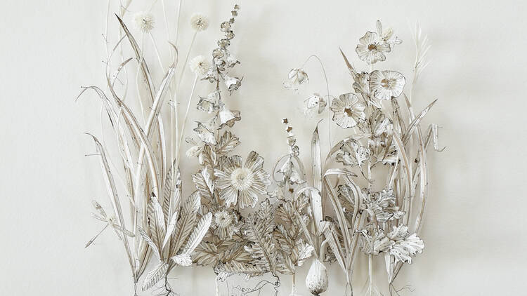 An arrangement of floral paper sculptures against a white backdrop by artist Colleen Southwell.