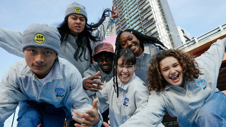 Dance crew L2R posing for a phot, wearing grey sweatshirts.
