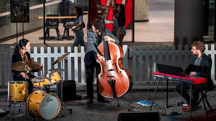 A jazz trio playing on an outdoor stage