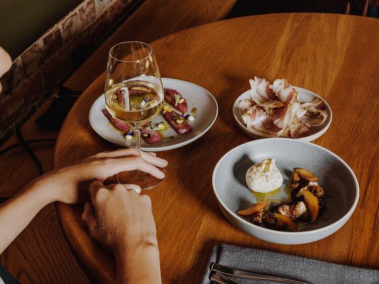 A diner lingering over dishes and a glass of wine