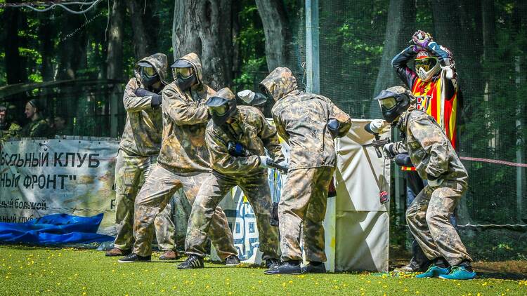 A group of people in tactical gear playing paintball. 