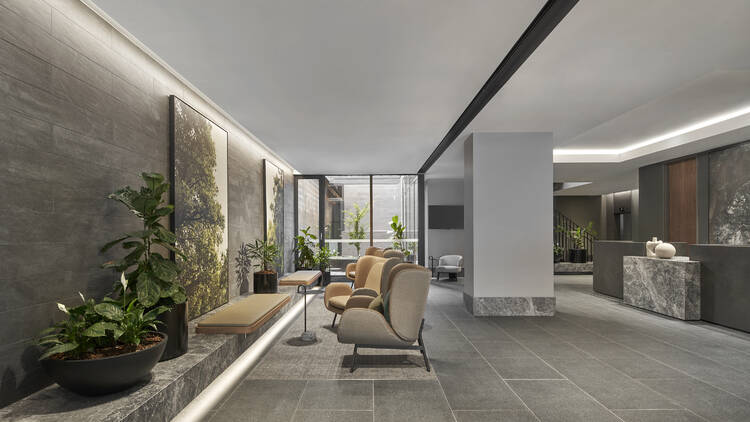 The lobby of the Melbourne Marriott Courtyard by Flagstaff Gardens. Grey tiles, greenery and seating.