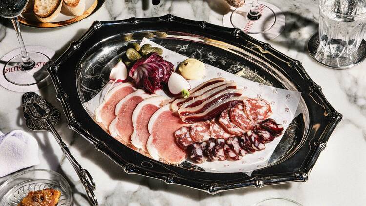 A silver platter topped with cured meats.