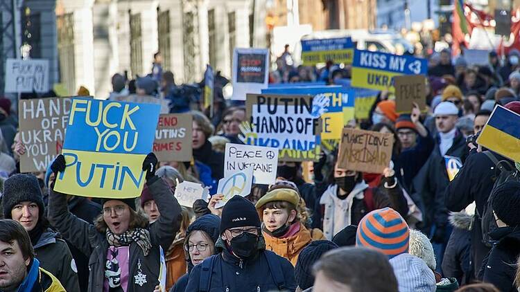 A group of people protesting against Putin and in support of Ukraine.