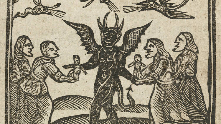 In a medieval woodcut, the devil, rendered as a horned man with wings and rooster feet, gives dolls to four old women witches while strange winged beasts fly around them.