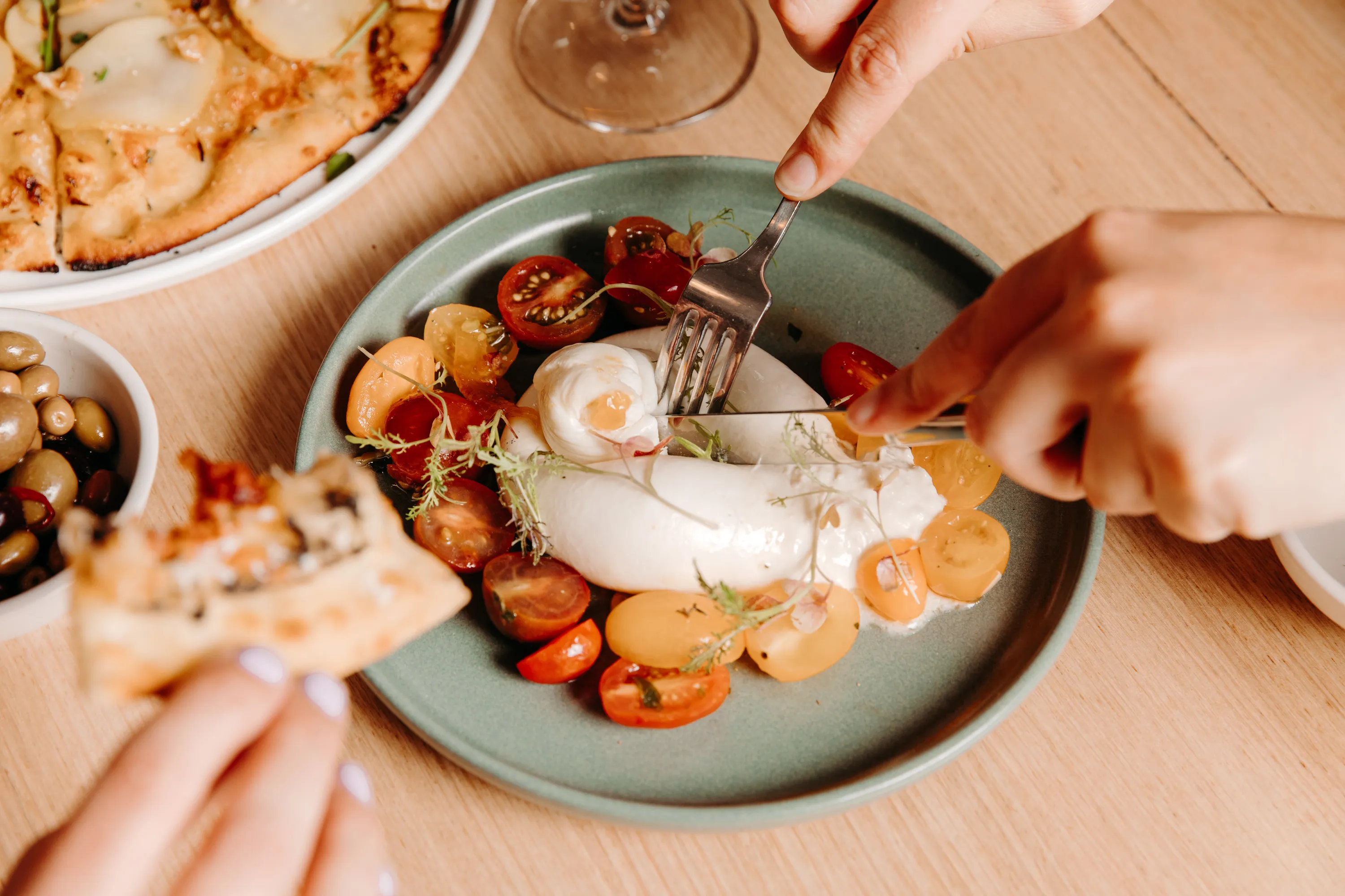 A platter of burrata and sliced tomatoes.