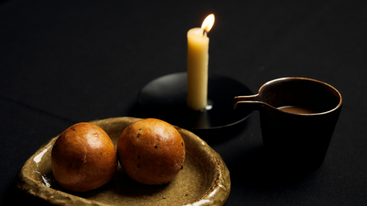 Bread rolls, a candle and a pot of gravy