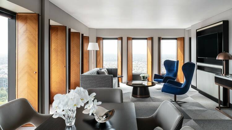 A hotel room with grey furniture and blue chairs