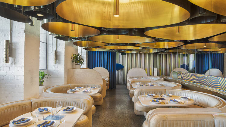 The interior of Elchi; golden chandeliers and beige leather couch fixtures.