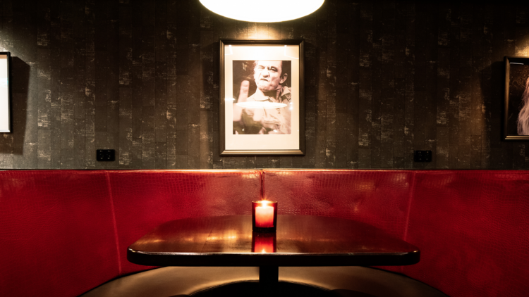 A red booth table with a picture of johnny cash above it