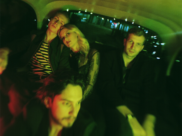 The band wolf alice sitting in the back of a car.