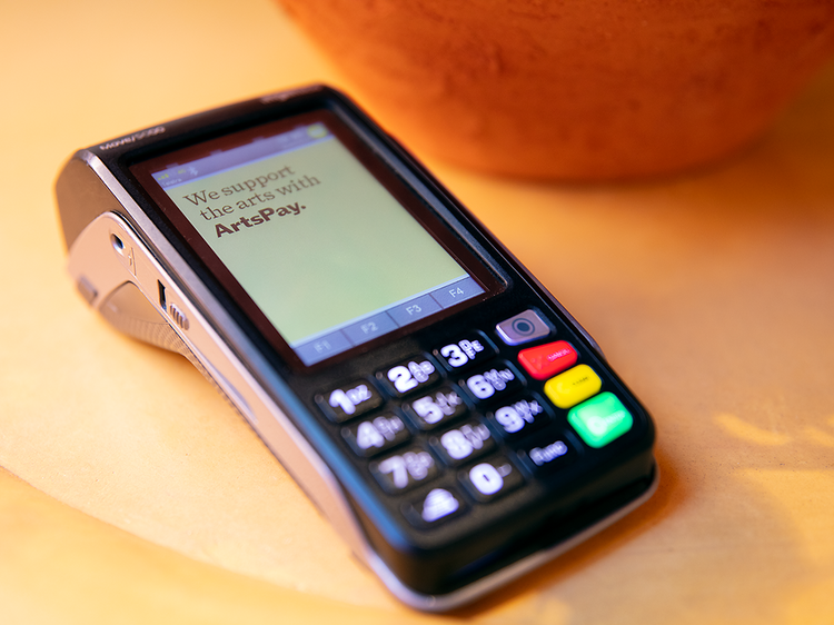 An ArtsPay payment terminal on a table