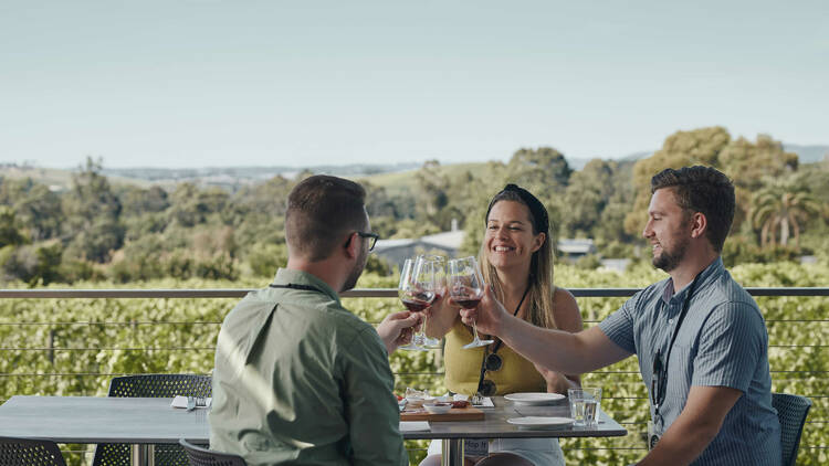 A group of three friends cheersing with wine glasses on a Hop It tour.