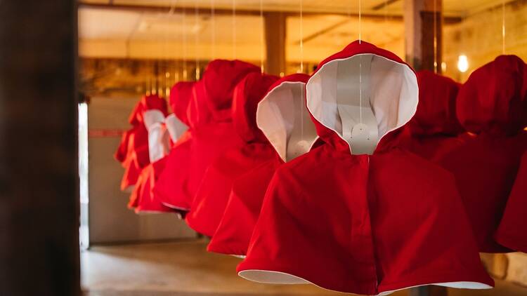 An art installation of red suspended capes
