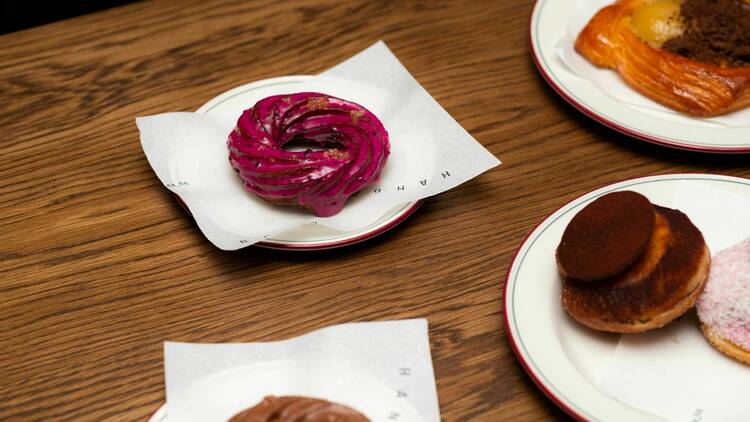 Donuts and crullers on plates with napkins.