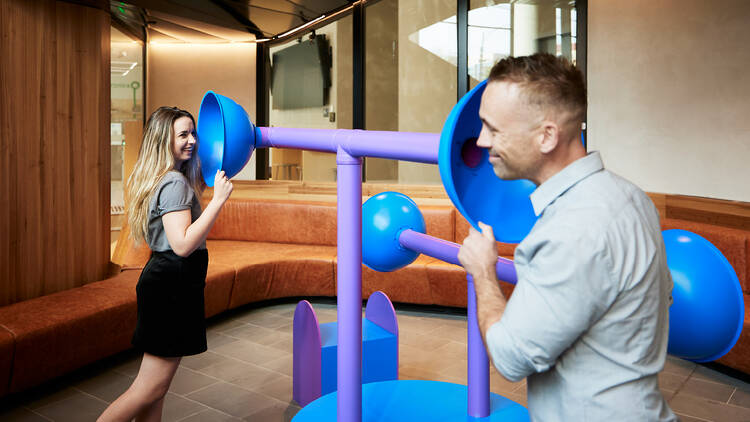 Two people playing with playground equipment.